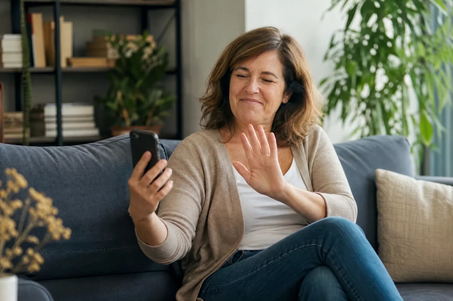 Une femme repose son téléphone après un appel non sollicité, dans son salon