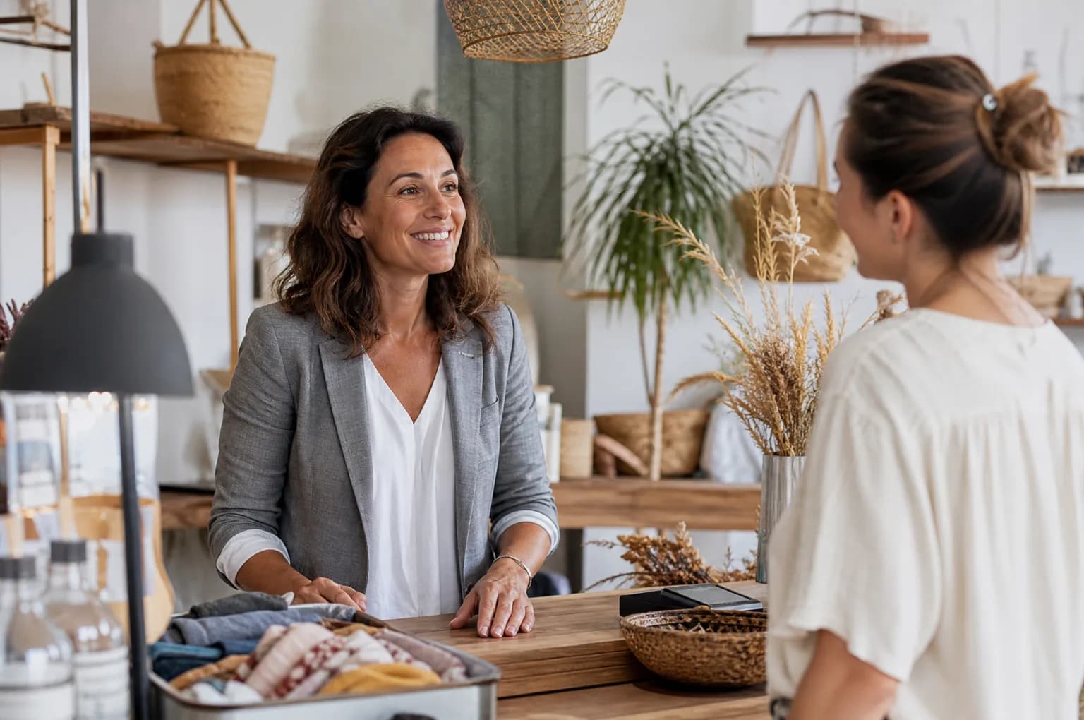 Une commerçante échange avec son employé derrière le comptoir de sa boutique